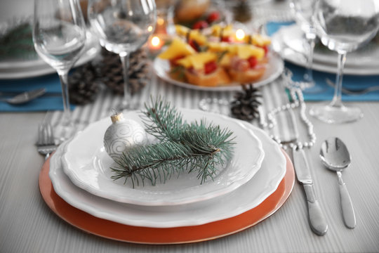 White plates with flatware on a Christmas table