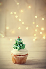 Christmas cupcake with lights on background