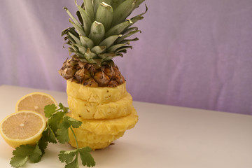 Pineapple slices. lemon and parsley on white table