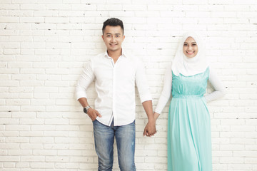 asian couple standing and smiling while holding each other hands