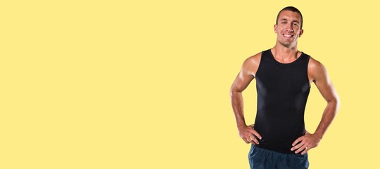 Composite image of happy athlete with hands on hip standing