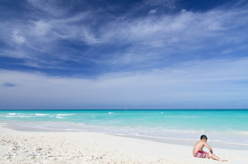 Fototapeta na wymiar Young Asian playing on white sandy beach