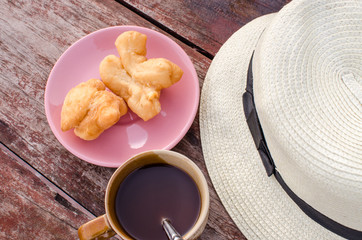 Youtiao (Chinese doughnut) and old style thai local coffee and on wooden table, Vintage style effect image