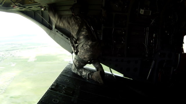 Crew member adjusts something in a CH-47 Chinook helicopter.