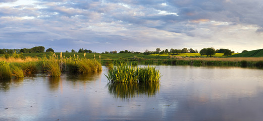 Fototapeta na wymiar liliowe jezioro wśród wiosennych pól 