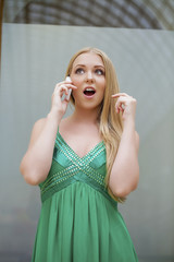 Young beautiful girl in the green dress talking on cell phone