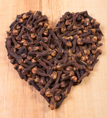 Heart of cloves on wooden table, seasoning for cooking