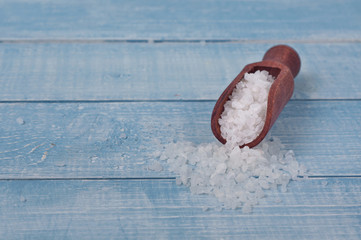 Obraz premium Sea salt in scoop on a wooden table