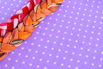 Embroidery threads of different colors on a purple background 