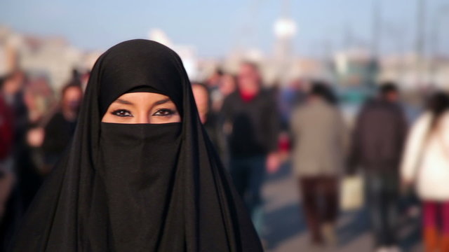 Woman dressed with black headscarf, chador on istanbul street, turkey