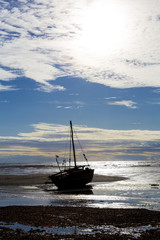 Nautical ship stranded on a beach under a blue cloudy sky in Madagascar