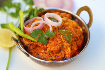 Butter chicken mutton curry or Indian style cottage cheese curry in a brass bowl with Salads.
