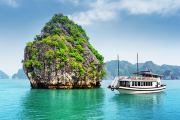 Beautiful view of karst isle and tourist boat in the Ha Long Bay