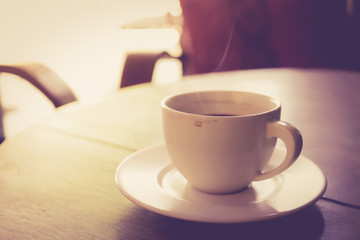 Cup of coffee on wooden table vintage color