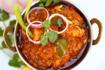 Butter chicken mutton curry or Indian style cottage cheese curry in a brass bowl with Salads.