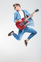 guitar player jumping while playing rock and roll
