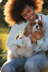 young african american black woman playing with dog sunset