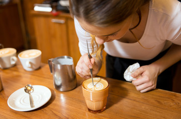 close up of woman making coffee at shop or cafe