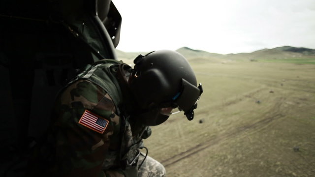 Soldier looking out of landing helicopter