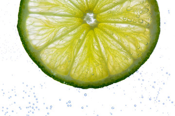 Fototapeta na wymiar lime slice falling or dipping in water 