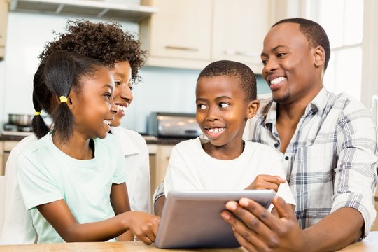 Happy family using tablet in kitchen
