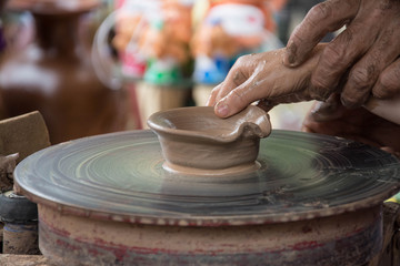Hands working on pottery wheel 