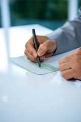 Businessman writing on paper 