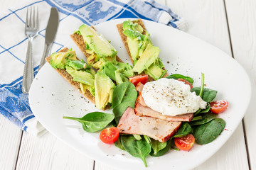 Poached Egg with Spinach, Tomatoes, Avocado, Crackers and Bacon