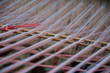 close up of weaving silk in traditional way at manual loom. Thailand