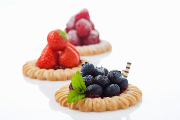 Drei Mürbeteig Obsttörtchen, Himbeeren, Erdbeeren, Blaubeeren,