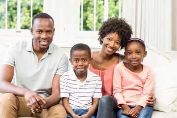 Smiling family sitting on the couch together