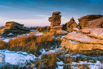 Spectacular sunrise on rocky hill mountain at snowy morning