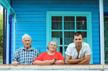 portret of family grandmother, grandfather, grandson near house