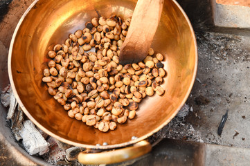 Coffee beans are roasting in pan. Traditional techniques.