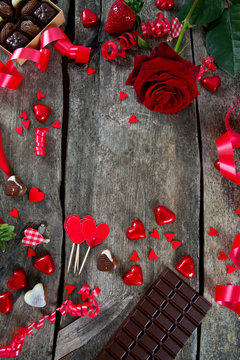 hearts, chocolate, flowers and ribbons on wooden surface