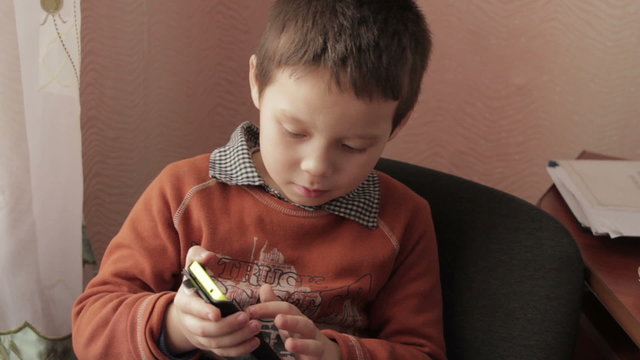 ittle boy playing a game on your smartphone