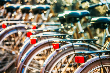 Row of city parked bicycles bikes for rent on sidewalk in Europe