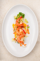 shrimps with salad on a white plate
