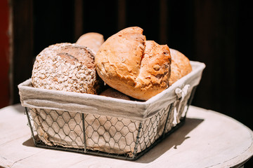 Rustic homemade bread in basket on an old vintage wood table