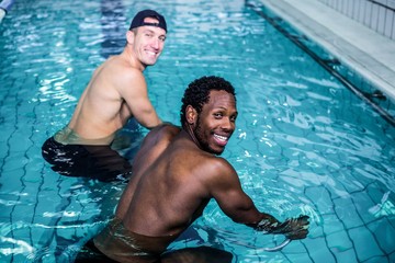Fit men cycling in the pool 