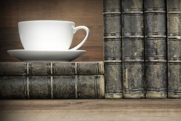 Old Shabby Books And White Cup On The Wood  Background