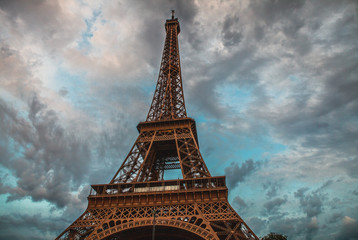 Close-up elements part of Eiffel tower in Paris against dramatic twilight sky at evening summer...