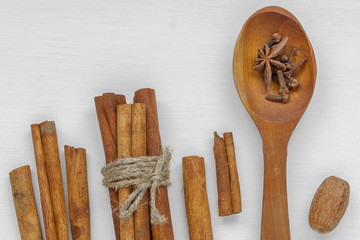 Cinnamon sticks, nutmeg and a wooden spoon with spices