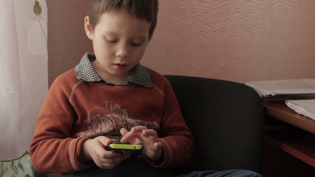 ittle boy playing a game on your smartphone