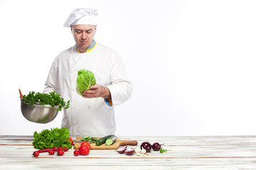 Chef cooking fresh vegetable salad in his kitchen