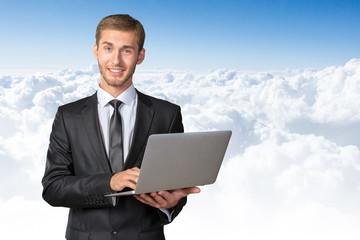 Young handsome businessman holding laptop