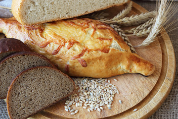 Fresh bread and different types of wheat ears..
