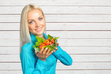 Beautiful girl eating fresh vegetable salad