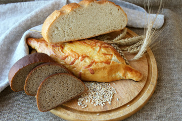 Fresh bread and different types of wheat ears..