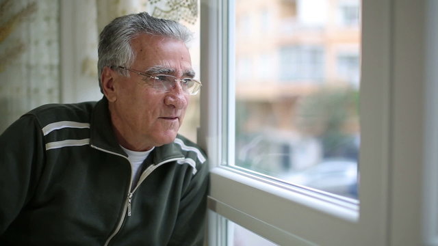 Senior man looking through window